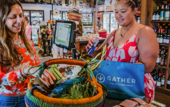 A woman with a basket of produce at a grocery store