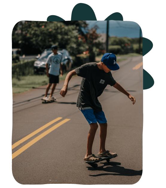 Young boys skateboarding on local road