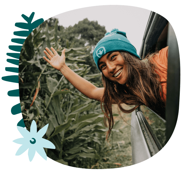 young woman waving out of a car window