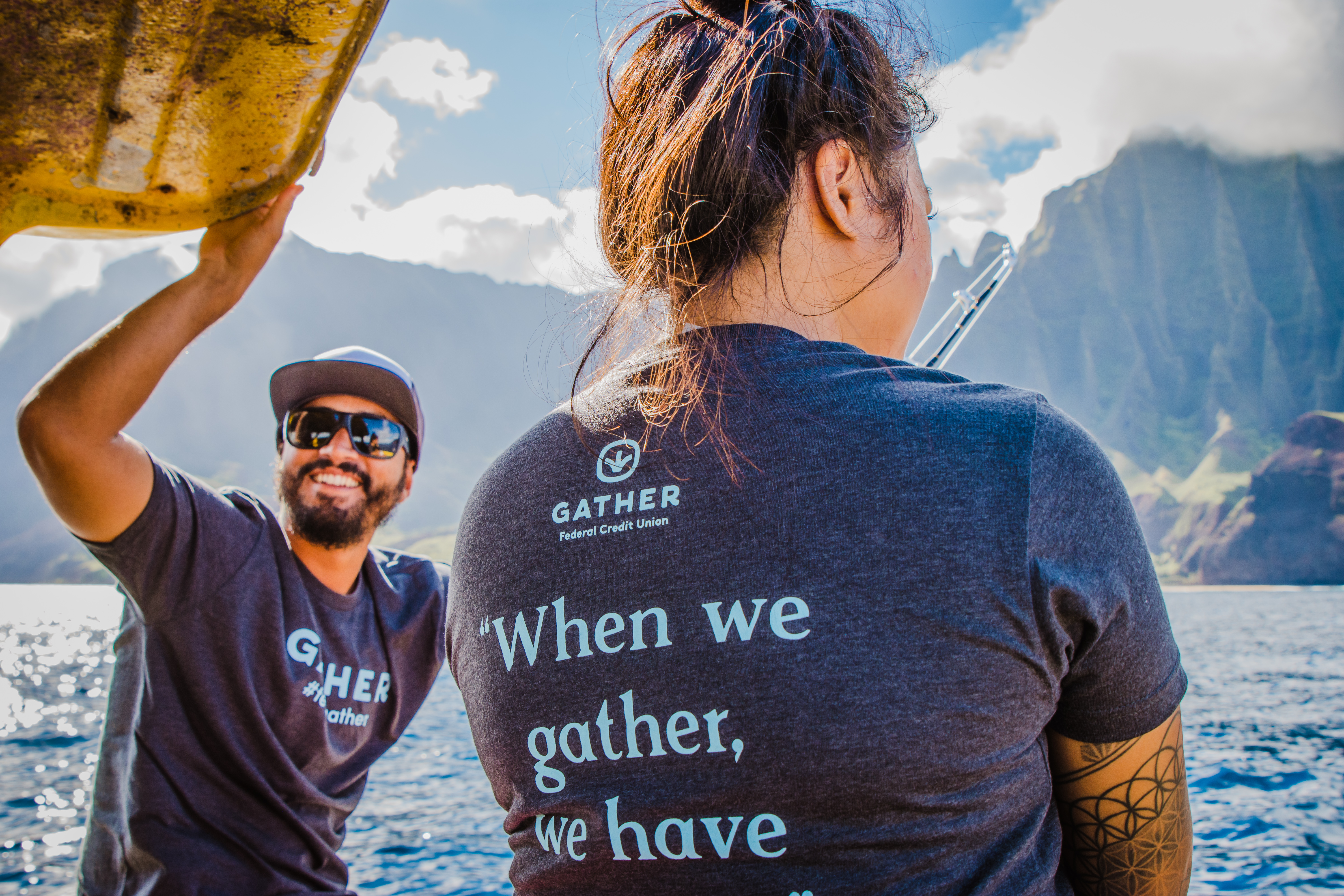 Two people on a boat wearing Gather Federal Credit Union shirt