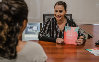 A gather representative showing a brochure to a customer