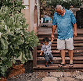 A grandfather helping his grandson down the stairs