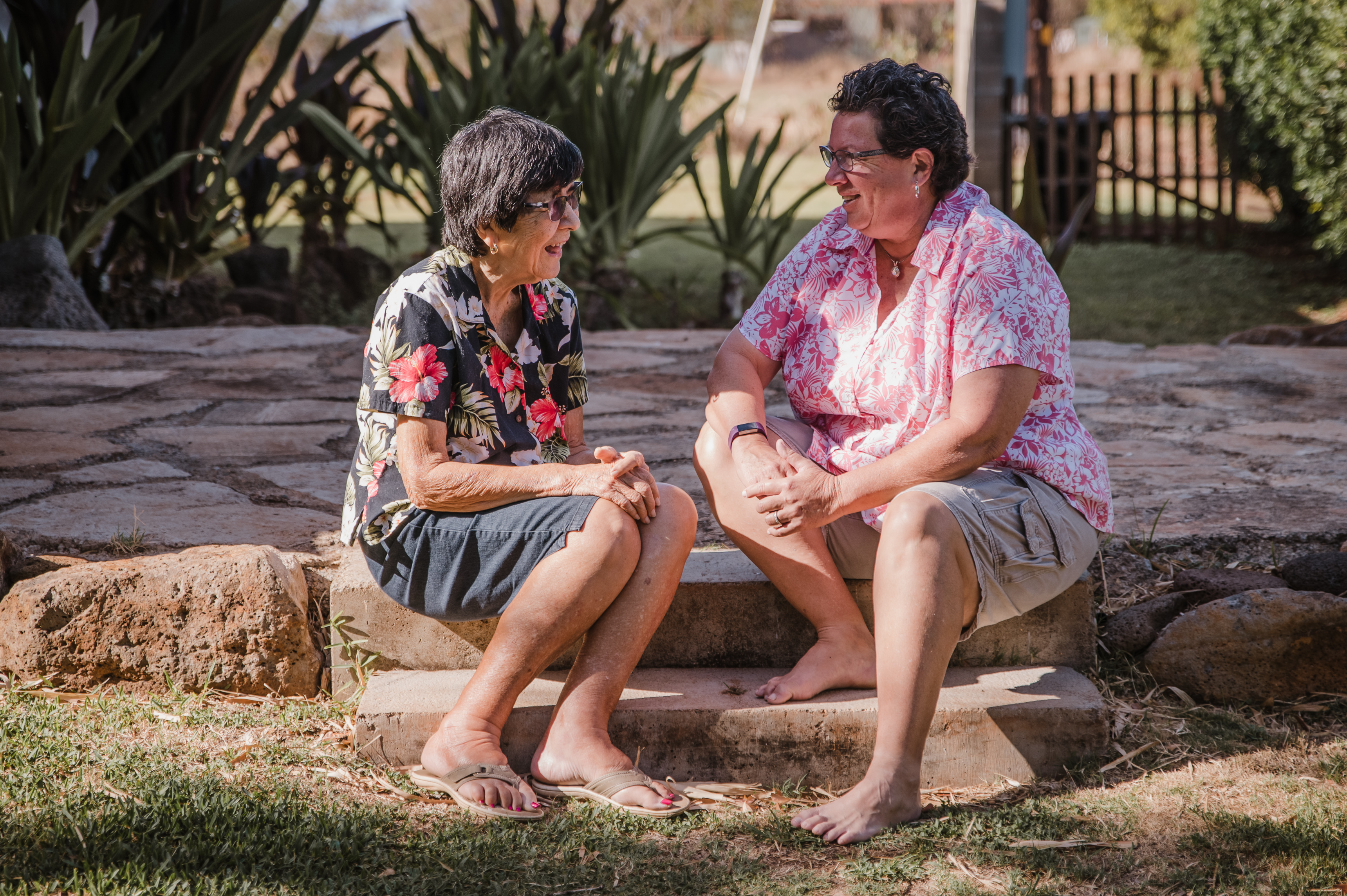 two elderly women in Hawaiian shirts smiling 