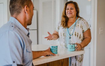 Man and woman having a conversation in kitchen.