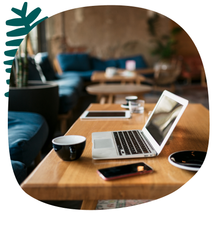 Computer, mobile phone and cup at coffee shop